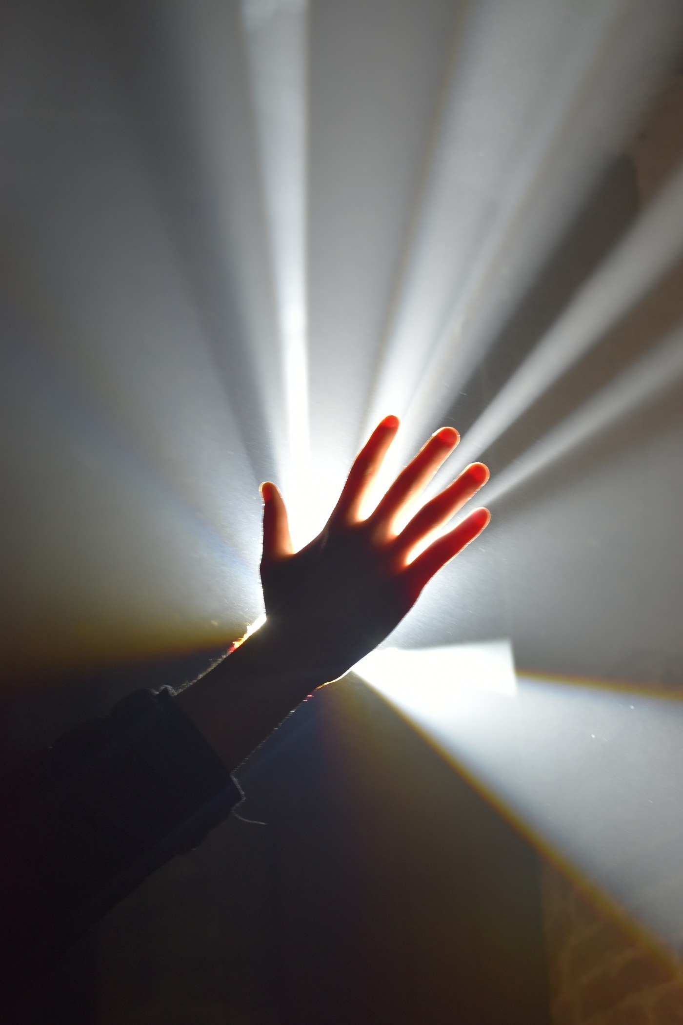 Rays of light passing through an outstretched hand